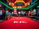 KJC gaming table at a luxurious casino with vibrant poker chips and a lively atmosphere.